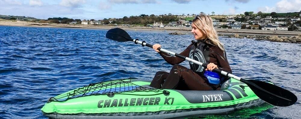 Jeune femme blonde pagayant sur le kayak gonflable Intex Challenge K1