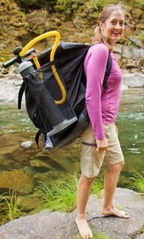Jeune femme équipe d'un sac à dos pour canoë gonflable et pompe manuelle
