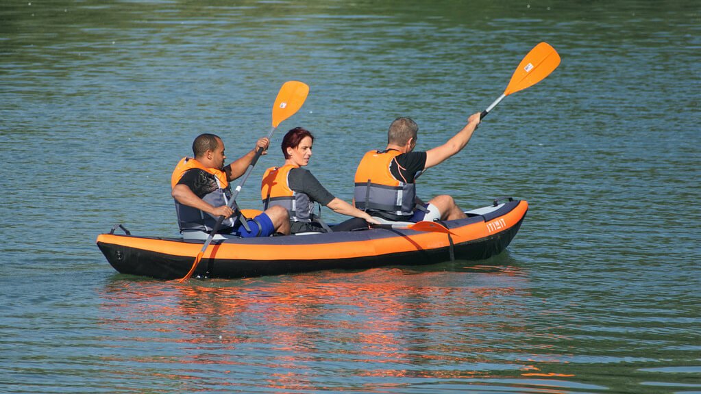 kayak gonflable 3 places orange naviguant avec 3 adultes