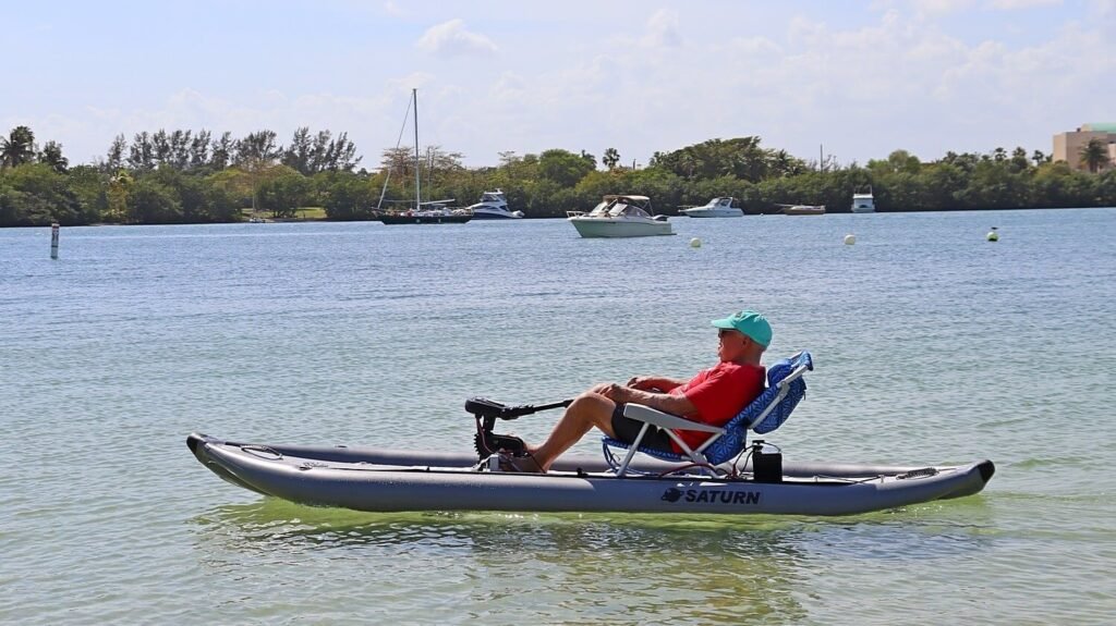 Homme âgé assis sur une chaise posée directement dans un canoé gonflable équipé d'un moteur