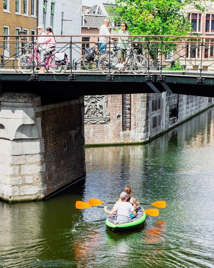 Kayak gonflable vert voguant sur un canal en ville
