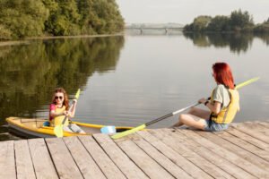 2 jeunes femmes en train de monter dans un kayak gonflable