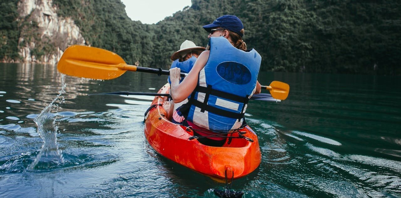 2 personnes en train de pagayer dans un kayak gonflable