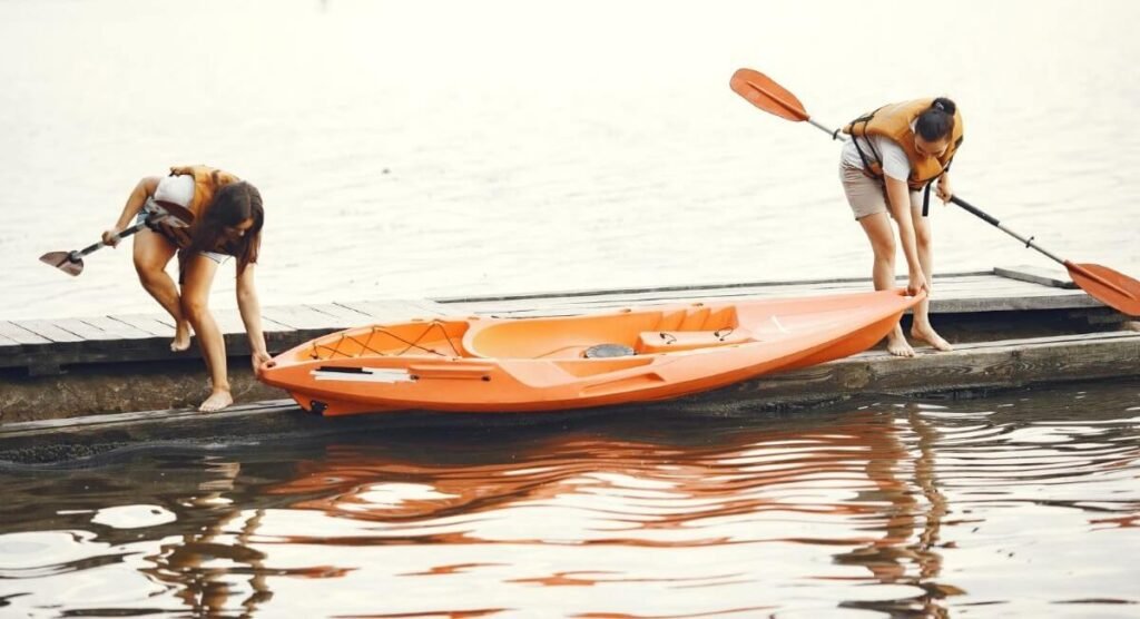 2 jeunes femmes mettant un kayak gonflable Ã  l'eau