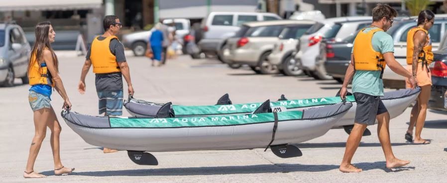 2 hommes et 2 femmes portant 2 kayak aqua marina laxo