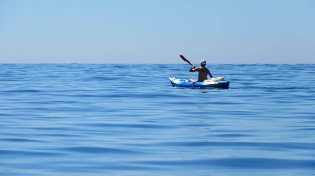 Femme pagayant seule sur un kayak gonflable