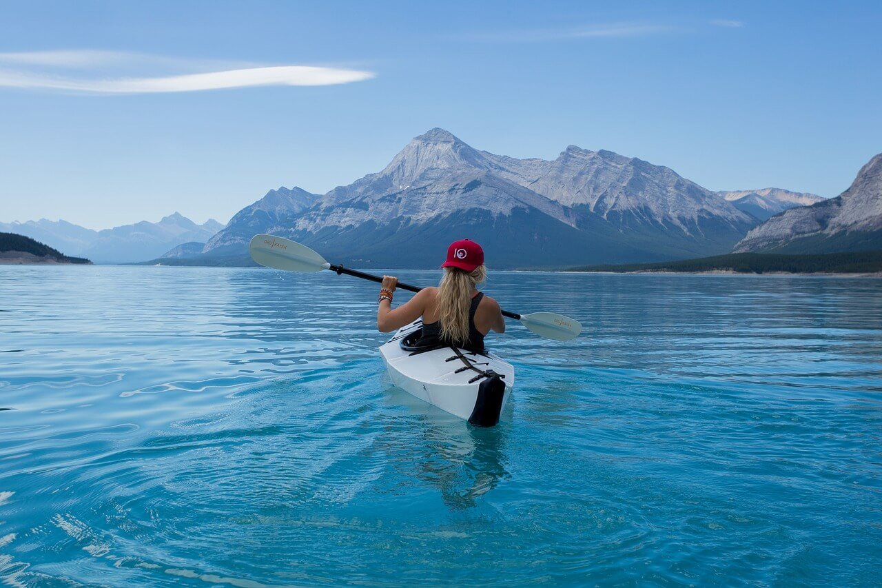 Jeune femme vu de dos pratiquant le kayak seul