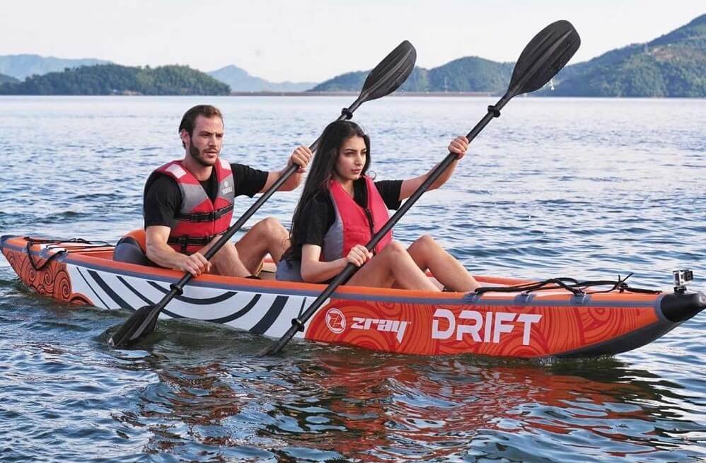 Jeune couple pagayant dans un kayak gonflable Zray Drift